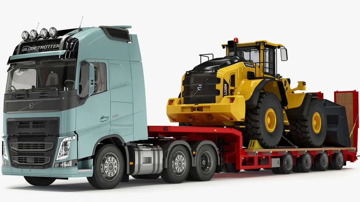 Prime mover pulling a lowbed trailer loaded with a wheel loader